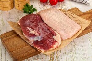 Raw duck breast over board photo