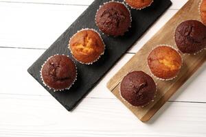 Delightful chocolate and vanilla muffins arranged on wooden serving boards in a bright kitchen setting photo