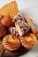 Assorted pastries and sweets arranged on a wooden platter during a food gathering photo
