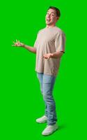 A person smiling and gesturing with hands in front of a bright green backdrop photo
