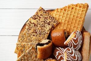 Assortment of traditional desserts displayed on a wooden plate with a rustic background photo