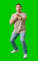 Man expressing fear while standing against a bright green background photo