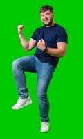 A strong man with fists raised, smiling confidently, on a bright green background photo