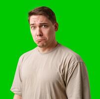 Man with a neutral expression poses against a bright green backdrop photo
