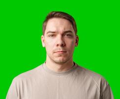A man standing against a vibrant green backdrop with neutral expression photo