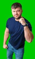 A strong man with fists raised, smiling confidently, on a bright green background photo
