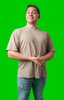 A cheerful man with a friendly smile poses against a bright green background photo