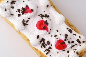 Delicious dessert with whipped cream, cherries, and chocolate sprinkles served on a white surface during a festive gathering photo