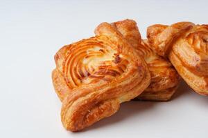 Freshly baked pastries arranged on a clean surface showcasing their golden-brown layers and swirl patterns photo