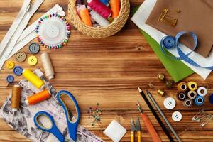 Crafting tools and materials arranged on a wooden table for sewing projects photo