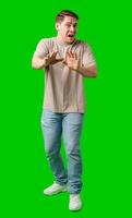 Man expressing fear while standing against a bright green background photo