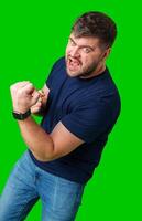 A strong man with fists raised, smiling confidently, on a bright green background photo