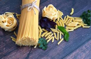 A rustic table setting with a burlap runner and a variety of pasta types. photo