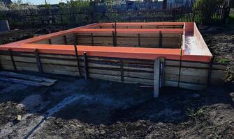 Wooden formwork with metal reinforcement prepared for pouring concrete. Installation using wire. Building a new house. photo