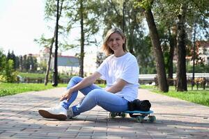 An active middle-aged woman rides a skateboard on an empty road or highway. An ordinary city woman relaxing on a skateboard after work. The concept of a modern lifestyle photo