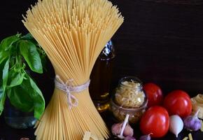 A rustic and inviting culinary scene with a variety of pasta types arranged on a burlap table runner. photo