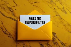 Roles and responsibilities message written on yellow envelope. Conceptual roles and responsibilities symbol. Copy space. photo