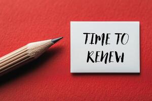 Time to renew message written on a white card with pencil on red background. Conceptual time to renew symbol. Copy space. photo