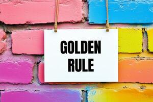 Golden rule message written on white card on colorful wall. Conceptual golden rule symbol. Copy space. photo