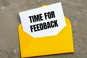 Time for feedback message written on yellow envelope. Conceptual time for feedback symbol. Copy space. photo