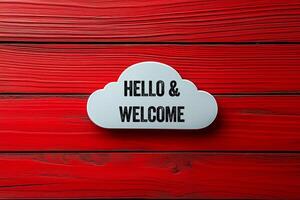 Hello and welcome message written on white cloud shape on red wooden background. Conceptual hello and welcome symbol. Copy space. photo