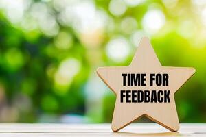 Time for feedback message written on wooden star shape. Conceptual time for feedback symbol. Copy space. photo