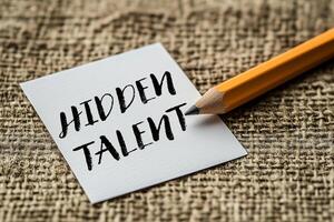 Hidden talent message written on a white card with pencil. Conceptual hidden talent symbol. Copy space. photo