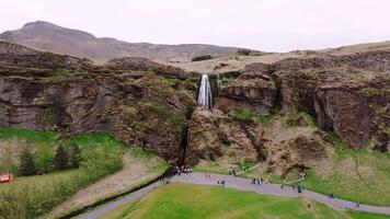 Waterfall Cascading Down Rugged Cliff in Iceland's Volcanic Landscape video