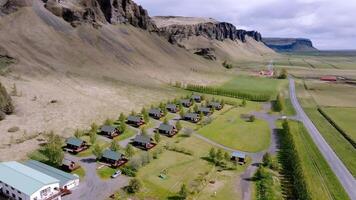 Cabins at the Base of a Rugged Cliff in Iceland with Open Plain video