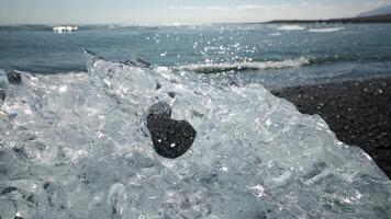 Translucent Ice Chunk on Dark Pebbled Beach in Iceland video