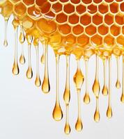 Golden honeycomb dripping with shiny liquid against white background, highlighting intricate hexagonal patterns and suspended droplets. Soft lighting accentuates texture photo