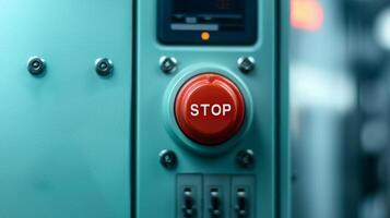 Safety guidelines for manufacturing. Red stop button on a teal control panel. photo