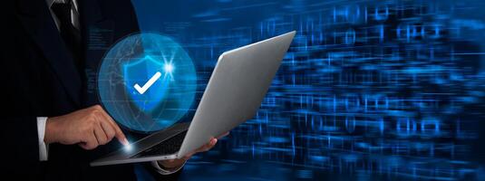 Businessman using laptop with security symbol on screen photo