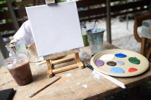 Frame canvas easel with paints palette and brushes with day light relax hobby in garden cafe class photo