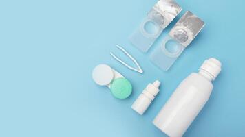 Contact lenses set with saline in bottle, tweezers, eye drops, plastic case with solution photo