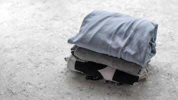 Stack of clothes folded on concrete background with copy space. Blue things photo