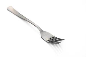 Unique fork rests on a clean white surface, highlighting its sleek design and purpose for dining photo