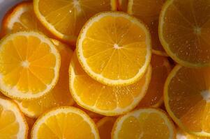 Bright slices of fresh oranges arranged artfully in a bowl capture the essence of summer vibrance and flavor photo