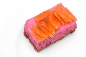 Unique culinary creation with vibrant pink beetroot mousse and smoked salmon on a white plate photo