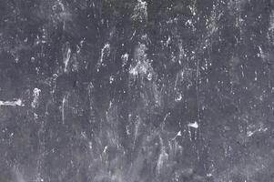 Dark textured surface reveals intricate patterns of wear and use in a creative workspace environment photo