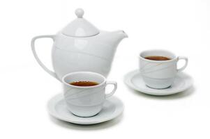 Elegant white tea set with steaming cups on saucers surrounded by tranquility of afternoon tea time photo