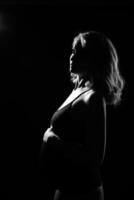 silhouette of a pregnant girl shooting on the background in the studio photo