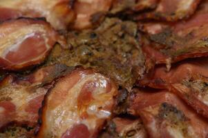 Crispy bacon slices arranged artfully on a rustic wooden surface in warm kitchen lighting photo