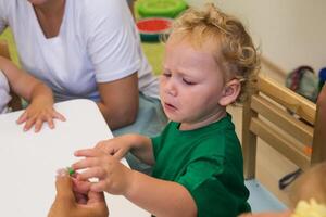 A child collects a puzzle for the development of fine motor skills photo
