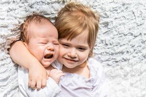charming little brother and sister asleep embracing on white background photo