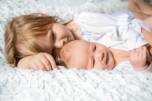 charming little brother and sister asleep embracing on white background photo
