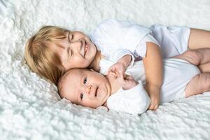 charming little brother and sister asleep embracing on white background photo