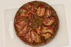 Savory bacon-topped cake showcases culinary creativity in a cozy kitchen setting photo
