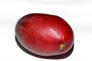 Red fruit resting on a white surface illuminated by gentle light in a cozy indoor setting photo