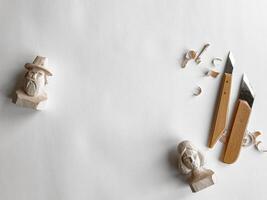 Wood carving art. Handcrafted figurines and tools on white background photo